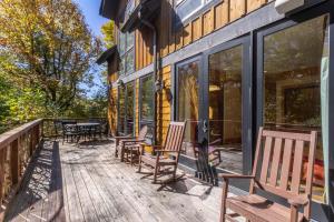 a deck with chairs and tables on a house at Rustic Cedar Rock Townhome at Eagles Nest in Banner Elk