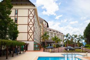 a hotel with a pool in front of a building at Loft 335 Vista Azul in Pedra Azul