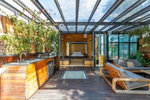 an outdoor kitchen and living room with a glass roof at Casa Wynwood Roma Norte in Mexico City