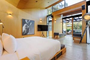 een slaapkamer met een groot wit bed en een televisie bij Casa Wynwood Roma Norte in Mexico-Stad