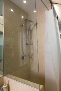 um chuveiro com uma porta de vidro na casa de banho em Amunì Taormina em Taormina
