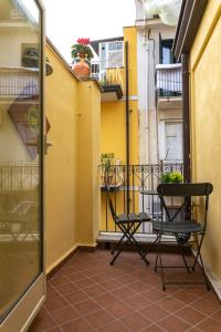 uma varanda com 2 cadeiras e uma mesa em Amunì Taormina em Taormina