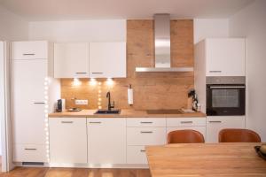 uma cozinha com armários brancos e uma mesa de madeira em Room 4 Art Apartments Nr.3 in Vienna Center em Viena