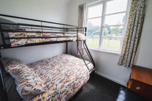 a bedroom with two bunk beds and a window at Cliff Top Cottage 