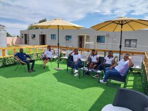 a group of people sitting in chairs under umbrellas at TOP TOWN LODGE in Butterworth