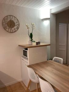 a dining room with a wooden table and white chairs at Appartement Type 2 de 40m2 avec spa privatif in Ventabren