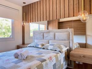 1 dormitorio con 1 cama con 2 toallas en Apartamentos VENTURA a 5 min do CENTRO by Achei Gramado, en Gramado