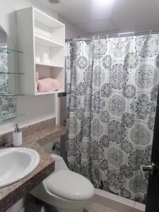 y baño con aseo y cortina de ducha. en Cómodo dpto full equipo 2 hab, seguridad y parqueo privado, en Guayaquil