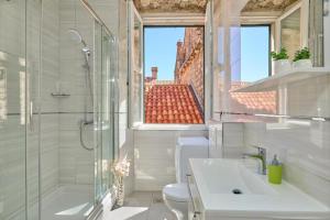 a bathroom with a shower and a toilet and a sink at Festa Apartments in Dubrovnik