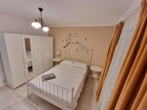 een slaapkamer met een wit bed en een wieg bij Aviatiei Apartments near Caramfil street in Boekarest
