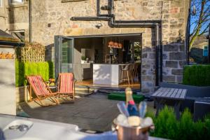 a patio with chairs and a kitchen in a building at Tranquil Four Bedroom Retreat in Buxton in Buxton