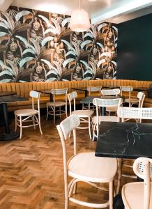 een restaurant met tafels en stoelen en een muurschildering bij The Inn Hotel, Ascend Hotel Collection in Arnolds Park