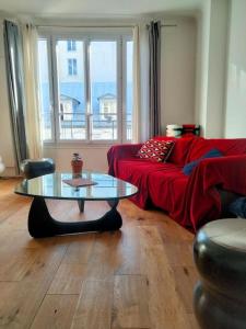 un soggiorno con divano rosso e tavolo di quiet and very central apartment a Parigi