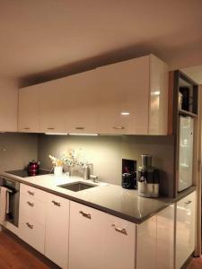 a kitchen with white cabinets and a sink at quiet and very central apartment in Paris