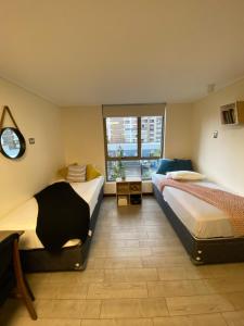 1 dormitorio con 2 camas y ventana en LivinnX Santiago, en Santiago