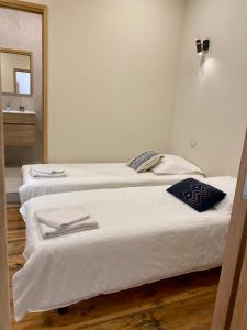 two white beds in a room with a mirror at CASA CITADELLA Bonifacio in Bonifacio