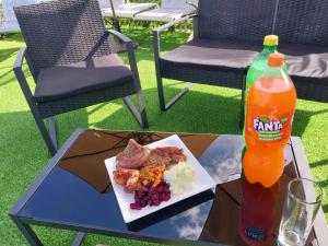 a table with a plate of food and a bottle of soda at TOP TOWN LODGE in Butterworth