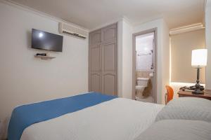 a bedroom with a bed and a television on the wall at Hotel Ayenda Boutique Real Capital Monteria in Montería