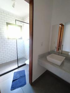 a bathroom with a sink and a toilet and a mirror at Casa Papa-Vento in Lençóis
