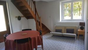 een woonkamer met een trap, een tafel en een bank bij Eco-gîte Le Batut 