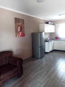 a kitchen with a refrigerator and a couch in a room at NAMU Apartments in Katima Mulilo