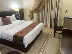 a bedroom with a bed and a desk and a chair at Hotel Hayatt in Nouakchott