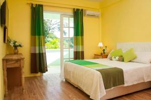 een slaapkamer met een bed met groene en gele muren bij Diamond View Cottages in Roseau