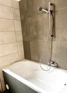 a bath tub in a bathroom with a shower at F14 Guest house by Small Home Budapest in Budapest