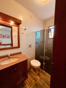 a bathroom with a toilet and a shower and a sink at Casa da Praia Pousada - Guesthouse in Torres