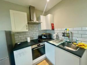 een keuken met een wastafel en een aanrecht bij Cosy 1 bedroom flat! in Londen