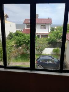 una ventana con vistas a un coche y una casa en Casa com Vista para o Mar, en Florianópolis