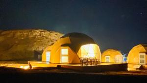 a group of domes with lights on them at night at Abdullah wadi rum camp in Wadi Rum +17 photos