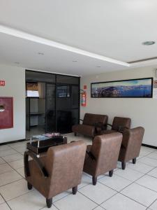 una sala de espera con sillas y una mesa en un edificio en Inter Hotel en Vitória