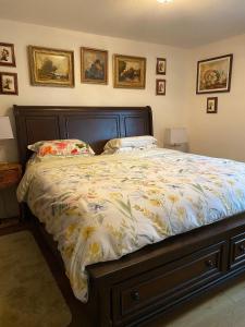 a bedroom with a bed with a floral comforter at Under the Tree - Bed & Breakfast in Kelowna