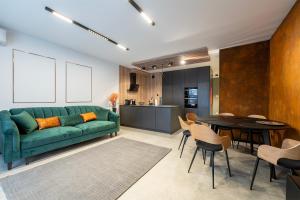 salon z zieloną kanapą i stołem w obiekcie Luxury Copper Apartment II w Łodzi