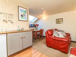 a kitchen with a red chair and a table at Bracken Cottage in Okehampton