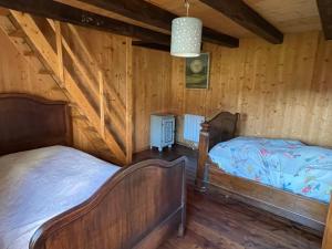 Dos camas en una habitación con paredes de madera. en La Manufacture Royale de Bains, en Bains-les-Bains 98 fotos más