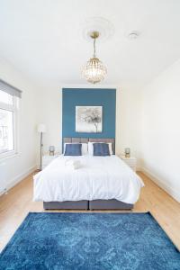sypialnia z dużym łóżkiem z niebieską ścianą w obiekcie Stunning and spacious house, with Free Parking and huge Garden, 5 Min to metro w Londynie