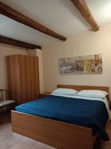 um quarto com uma cama grande e um cobertor azul em Deattellis House Casa vacanza em Campobasso