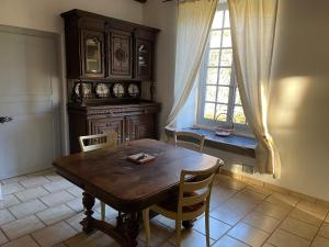 uma sala de jantar com uma mesa de madeira e uma janela em La Manufacture Royale de Bains em Bains-les-Bains