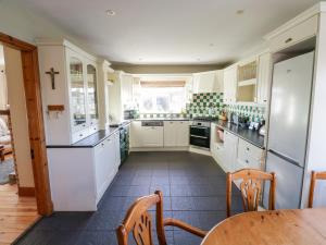 a kitchen with white cabinets and a table and chairs at Home Farm Retreat in Williamstown