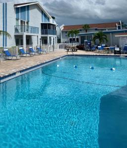 a large blue swimming pool with chairs and a building at Madeira Beach 2 Bedroom, 1 Bath 230 in St. Pete Beach