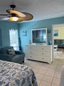 a bedroom with a bed and a dresser with a mirror at Madeira Beach 2 Bedroom, 1 Bath 230 in St. Pete Beach