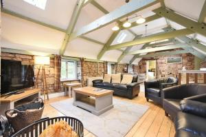 a living room with leather furniture and a stone wall at Millstone in Lucker