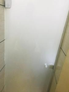 una parete bianca in bagno con luce di Hotel Gasometro a San Paolo