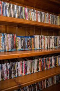 un estante de libros lleno de DVD en Beechworth On Bridge Motel, en Beechworth