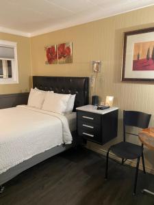 una camera con letto, scrivania e sedia di Oreland Motel a Flin Flon