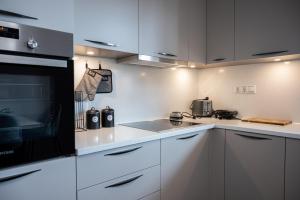 a kitchen with white cabinets and a black microwave at Archontiko in Argos