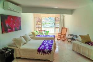 a hotel room with two beds and a window at Hotel Bahia Taganga in Taganga