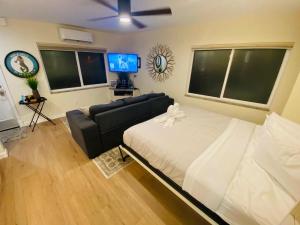 una camera con letto, divano e TV a schermo piatto di Pass a grille Gulf Way Beachfront 13 a St Pete Beach